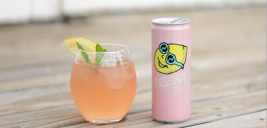 Roseade Spritzer Rose Lemonade Can and One in Glass Cup with Lemon